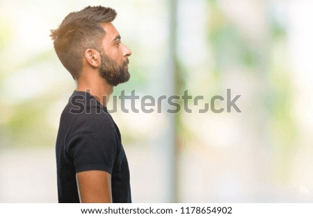 Adult hispanic man over isolated background looking to side, relax profile pose with natural face with confident smile.