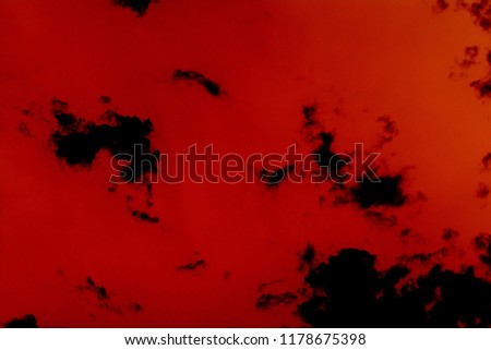 black clouds on a red background