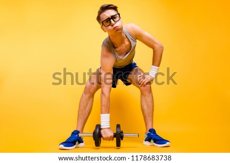 It's too hard for me! Full length, legs, body, size portrait of youth man look at camera can not lift dumbbells from the floor isolated on vivid yellow background Royalty-Free Stock Photo #1178683738