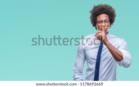 Afro american business man wearing glasses over isolated background asking to be quiet with finger on lips. Silence and secret concept.