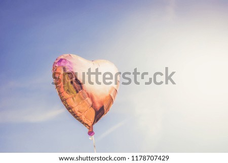 Heart shaped ballon on the sky background, toned image