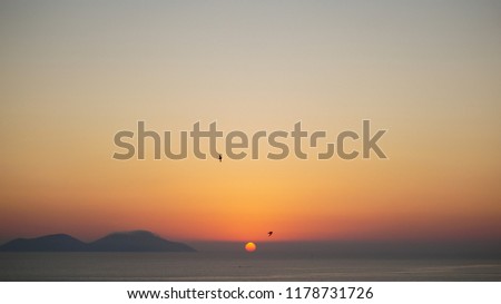 Soft yellow orange sunset on Mediterranean with small island