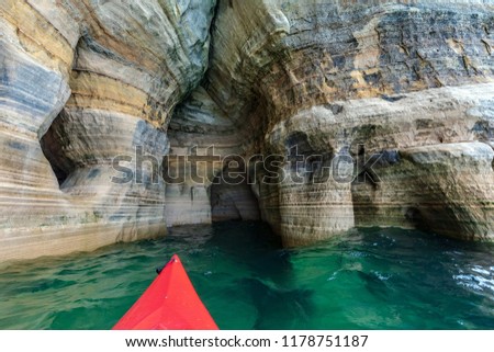 A red kayak in a Lake Superior Sea Cave under Miners Castle at Pictured Rocks National Lakeshore in the Upper Peninsula of Michigan. Munising, Michigan