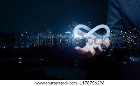 Businesswoman shows sign of infinity on the background of the city. The concept of unlimited Internet. Royalty-Free Stock Photo #1178756296