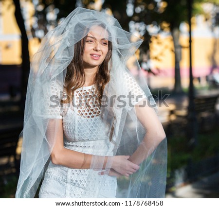 Fashion photo of a beautiful bride. Happy bride in a stylish white dress. Stylish wedding bride with bouquet and amazing modern dress.