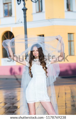 Fashion photo of a beautiful bride. Happy bride in a stylish white dress. Stylish wedding bride with bouquet and amazing modern dress.