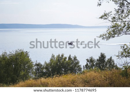 Blue water, the sea, the lake or the river, the coast with the field, a track. Autumn landscape