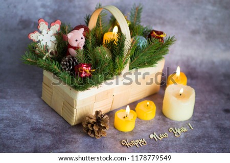 
A pink pig with Christmas decorations in front of a tree and candles.
Christmas composition. A statuette of the new year of 2019 - a pig surrounded by boxes of Christmas gifts