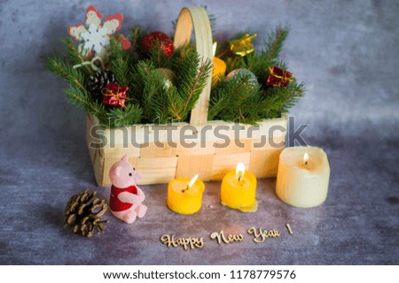 
A pink pig with Christmas decorations in front of a tree and candles.
Christmas composition. A statuette of the new year of 2019 - a pig surrounded by boxes of Christmas gifts