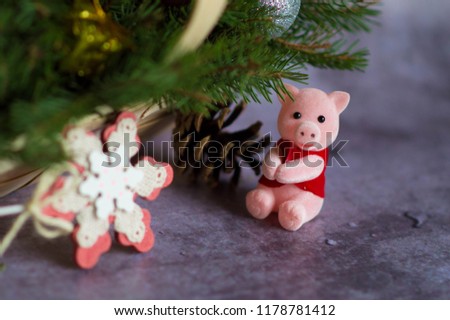 Christmas composition. A statuette of the new year of 2019 - a pig with Christmas decorations in a basket sitting on sprigs of spruce with gifts, toys and candles on the background