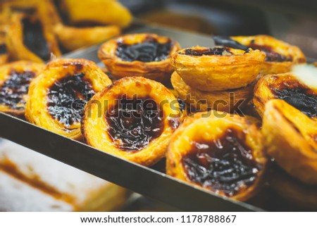 Traditional Portuguese egg tart pasty cakes, dessert Pasteis de nata with different portuguese pastry on the cafe store window, pastel de nata
