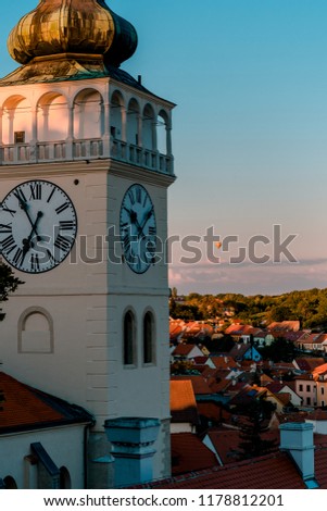 Awesome picture of old tower of town hall at Mikulov with hot air balloon behind.