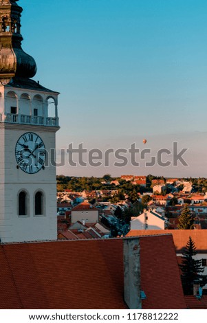 Picture of old tower of town hall at Mikulov on the sunset with the hot air balloon on the background.