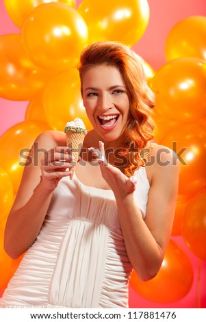 portrait of happy girl with ice cream against balloons