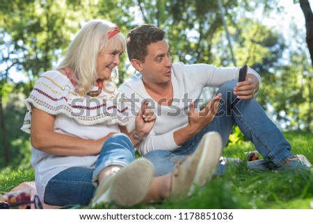 Being surprised. Cheerful female person feeling happiness while sitting near her son