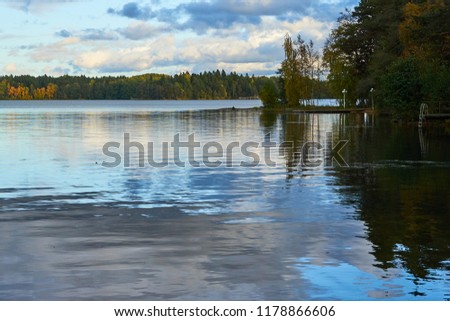                        Sunset on the lake in autumn with cloudy sky and reflection in water. Natural background.        
