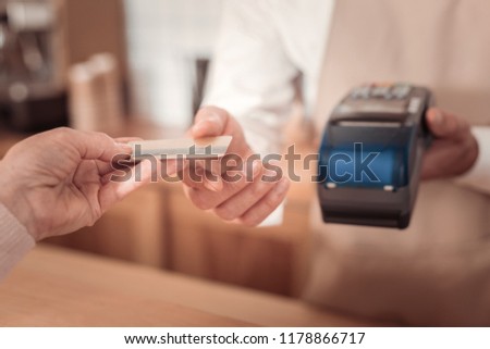 Electronic banking. Selective focus of a credit card being given to the cashier in the cafeteria