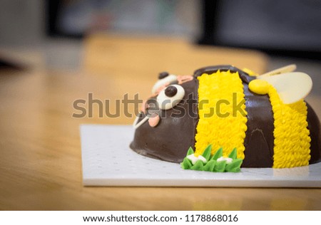 A cake in the shape of a bee. Yellow birthday cake. Copy space.