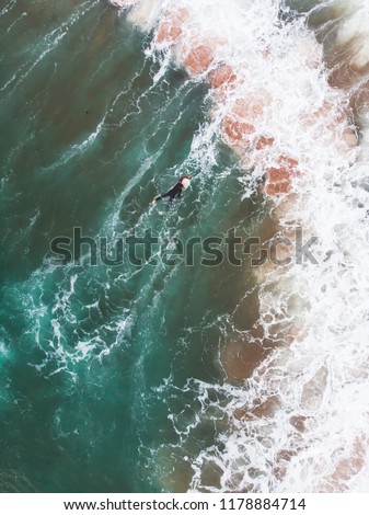 View of Praia do Guincho, Guincho beach, a popular Atlantic Ocean beach on Portugal's Estoril coast, municipality of Cascais, with surfers surfing on the waves, shot from drone