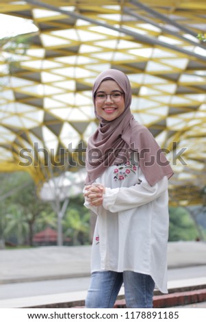 Cute little Asian girl wearing hijab just chill at the park in the morning. Portrait of beautiful ladies wearing hijab fashion.