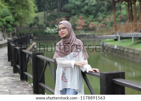 Cute little Asian girl wearing hijab just chill at the park in the morning. Portrait of beautiful ladies wearing hijab fashion.