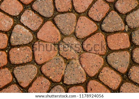 Red circular paved bricks with dirty moss and worn age