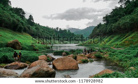 Perspective view of stream which is flowing in the middle of green huge hills