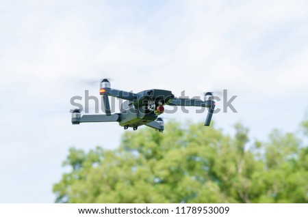 The drone hovering in a bright blue sky.
