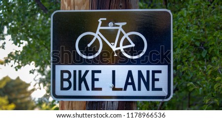 Bike lane road sign with trees in the background