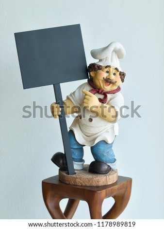 chef doll holding signs on wall background