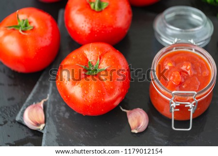Adjika sauce made of pepper, garlic and spices on a black background. Sauce. Food background.