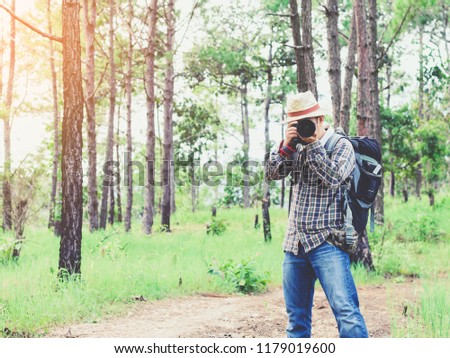 Nature photographer take photos with camera in forest