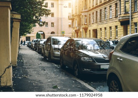 parked used cars stand on street parking during the day