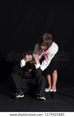 Sadness and stressed asian boy in suit holding the head with hands (face palm) and little girl in business clothes standing shoulder hand in hand. business kids concept.