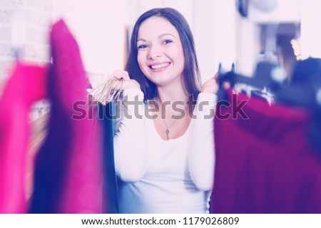 Portrait of young woman standing happinnes with bags  in  clothes shop
