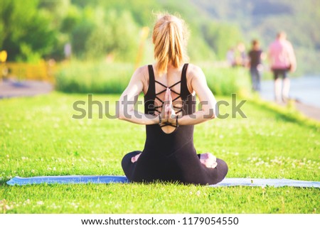 Beautiful young blonde girl doing yoga outdoors