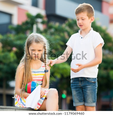 portrait of angry girl in elementary school age not playing with friend in park outdoors