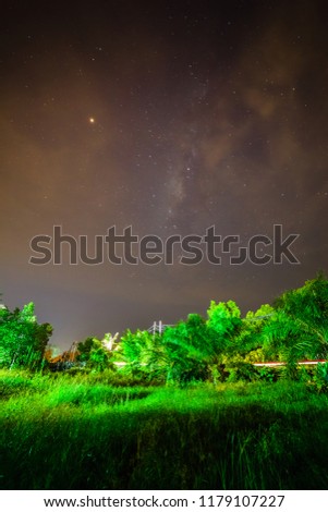 Milky way over a beach with a log of wood