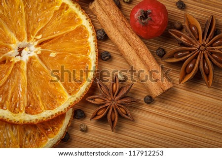 Kitchen herbs with dried orange and paradise apples on wooden background. Focused on anise star.