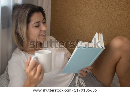 Person reading a book lying on the bed