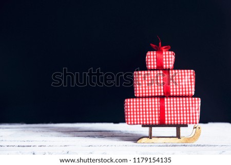 Sledge toy with gifts on a black background. Christmas concept.
