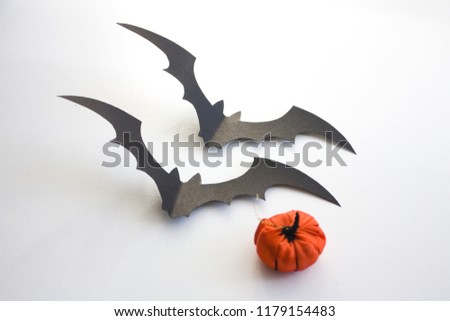 Black 3d paper bats for halloween with small pumpkin isolated on white background
