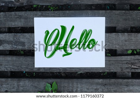 Hands Holding Square Card With hello word In The wooden Background