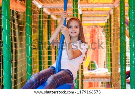 Beautiful little girl is playing in the children's playroom.