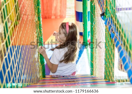 Beautiful little girl is playing in the children's playroom.