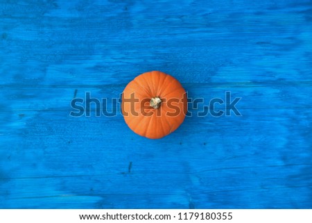 pumpkin on blue wooden table, top view and free space for text