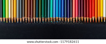 Colored pencils texture. Foreground. All the range of colors of the rainbow. Start of school Beautiful wallpaper. Isolated on black background.
