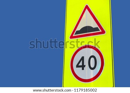 Speed Bump and 40 Speed limit traffic signs on the yellow shield isolated on the blue background. Red triangular and round warning road signs warning of a bumpy road ahead and speed limitations
