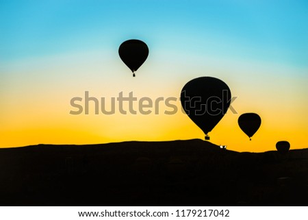 Hot air balloons floating in the sky with backlit colorful background behind