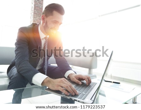 Successful man working on laptop in modern office